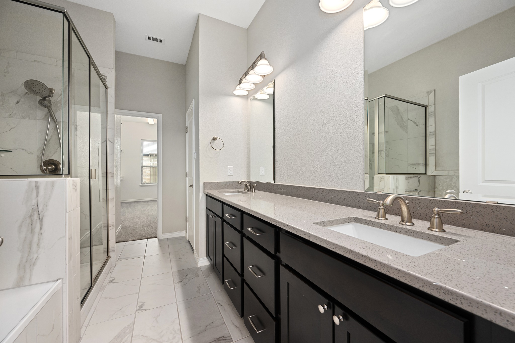 313 Adams Street Georgetown, TX 78628 - Photo 12 of 20 a bathroom with a granite countertop sink a large mirror and a shower