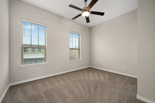 a view of an empty room with a chandelier fan