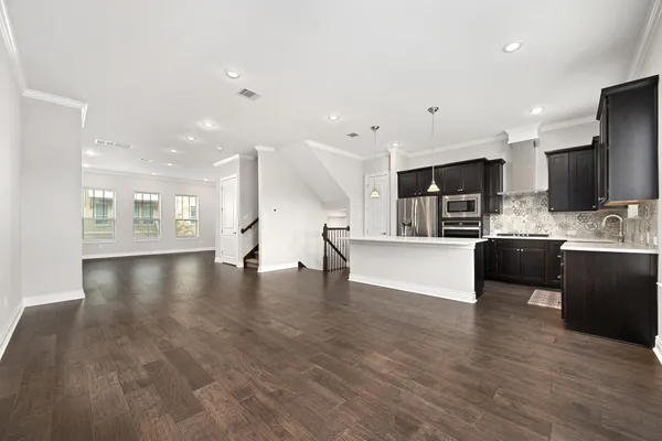a kitchen with stainless steel appliances kitchen island granite countertop a sink stove and refrigerator