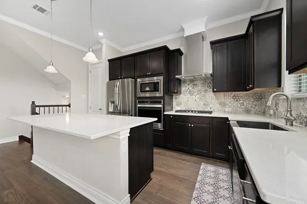 a kitchen with a sink center island and wooden floor