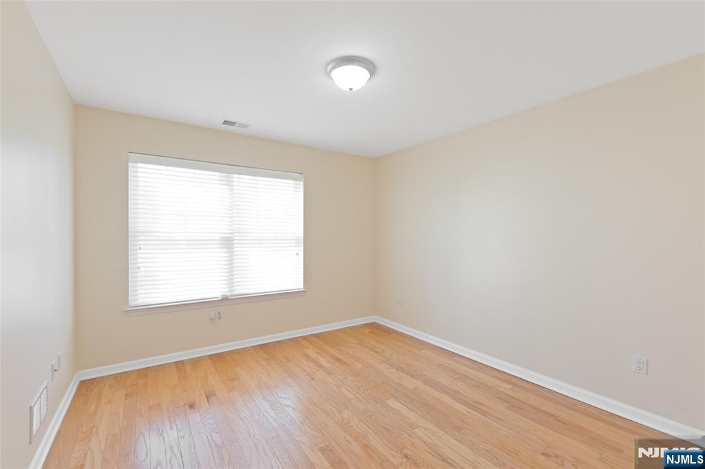 902 Spruce Street Roselle, NJ 07203 - Photo 13 of 32 an empty room with wooden floor and windows