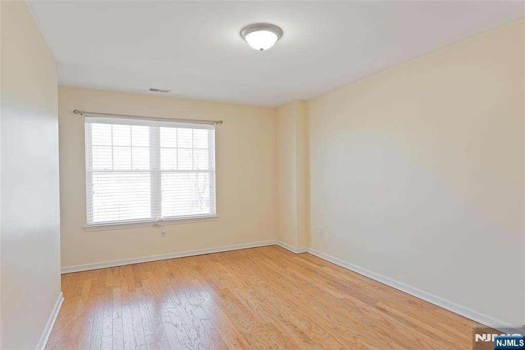 902 Spruce Street Roselle, NJ 07203 - Photo 17 of 32 an empty room with wooden floor and windows