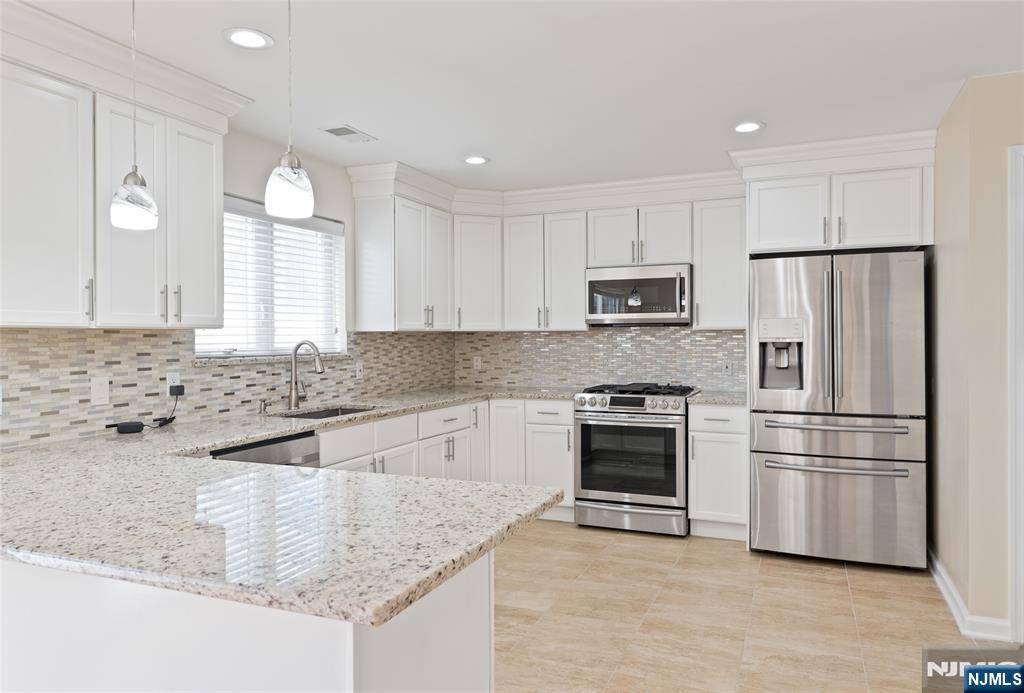 902 Spruce Street Roselle, NJ 07203 - Photo 2 of 32 a kitchen with granite countertop a refrigerator stove and microwave