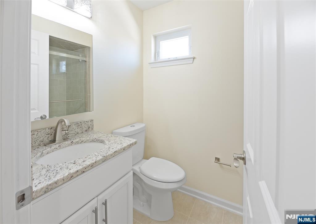 902 Spruce Street Roselle, NJ 07203 - Photo 22 of 32 a bathroom with a granite countertop sink toilet and a mirror