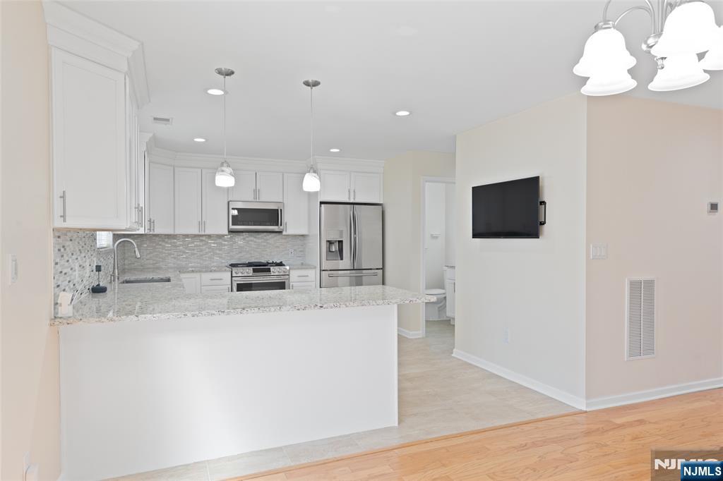 902 Spruce Street Roselle, NJ 07203 - Photo 3 of 32 a large kitchen with stainless steel appliances granite countertop a stove a sink and a microwave
