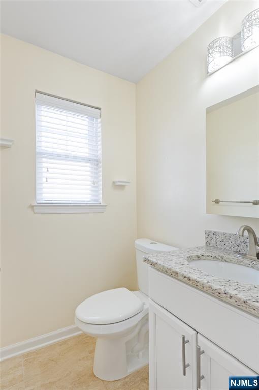 902 Spruce Street Roselle, NJ 07203 - Photo 10 of 32 a bathroom with a granite countertop toilet sink and mirror