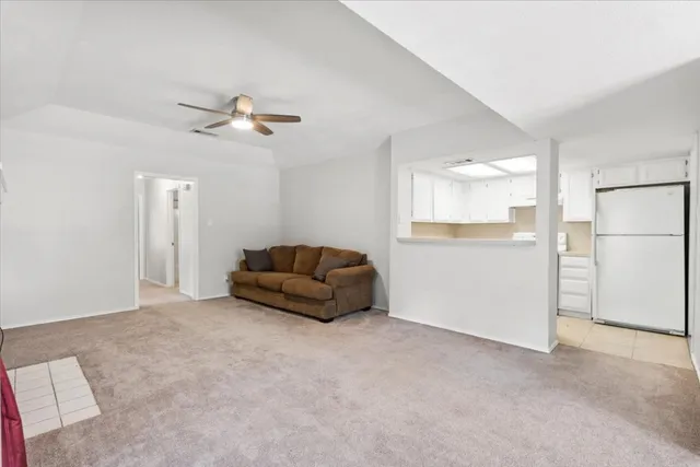 a living room with furniture and a ceiling fan