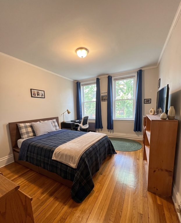 98 Strathmore Road, Unit 2 Boston, MA 02135 - Photo 3 of 11 a spacious bedroom with a bed and wooden floor