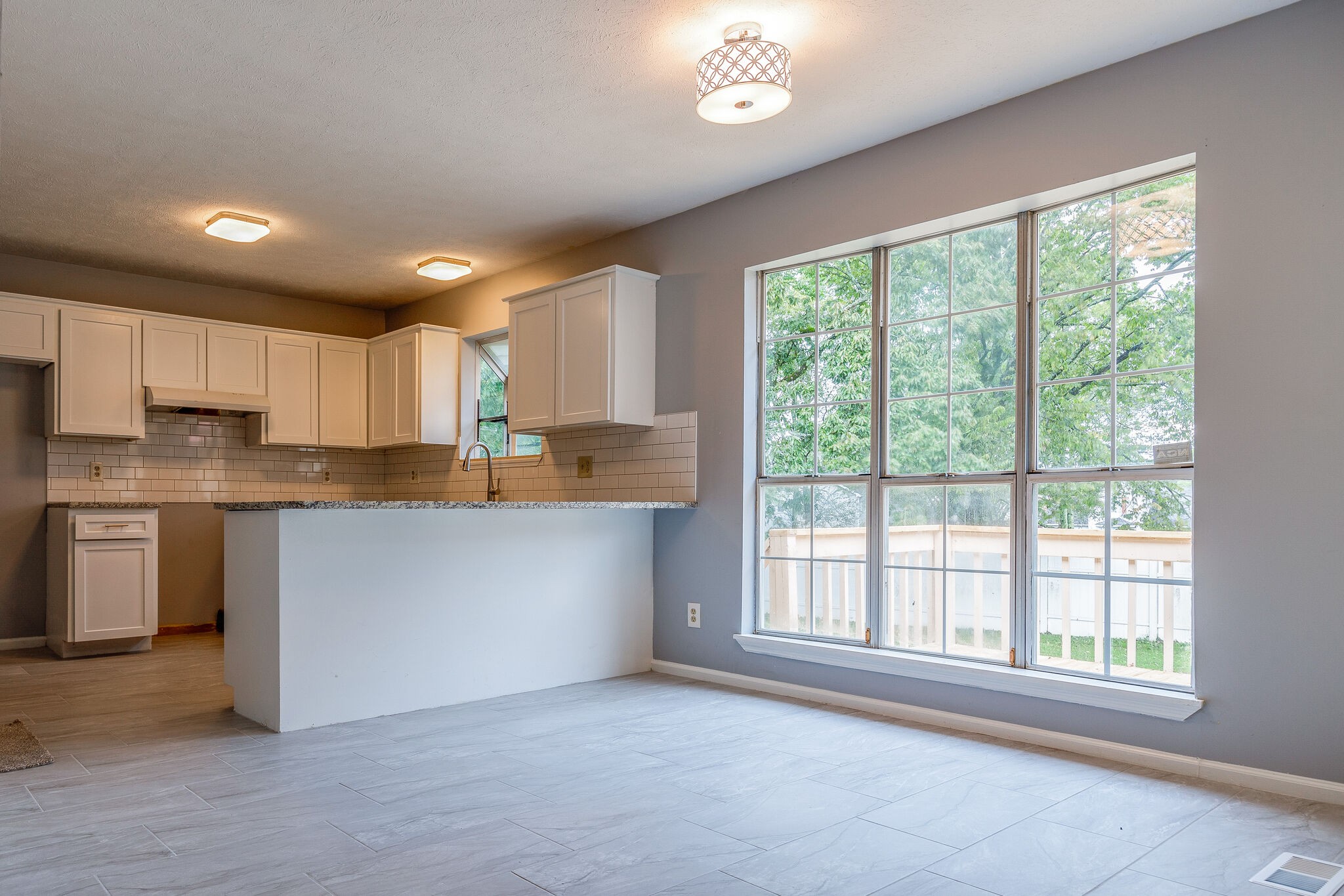 3218 Country Hill Road Antioch, TN 37013 - Photo 6 of 22 a kitchen with stainless steel appliances granite countertop a stove a sink a refrigerator white cabinets and a large window