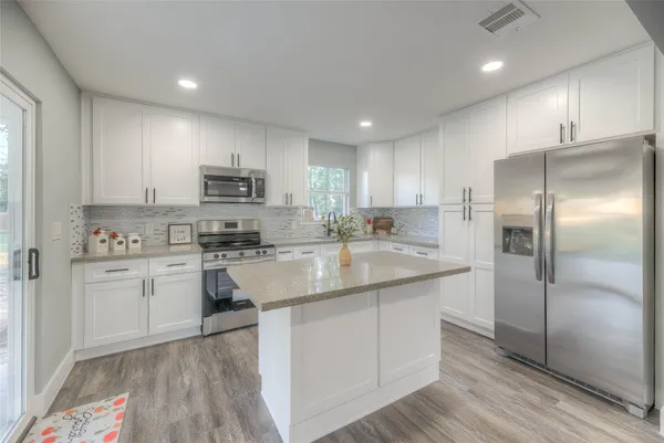 a kitchen with kitchen island a sink stainless steel appliances and cabinets