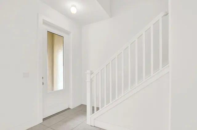 a view of staircase with railing and white walls
