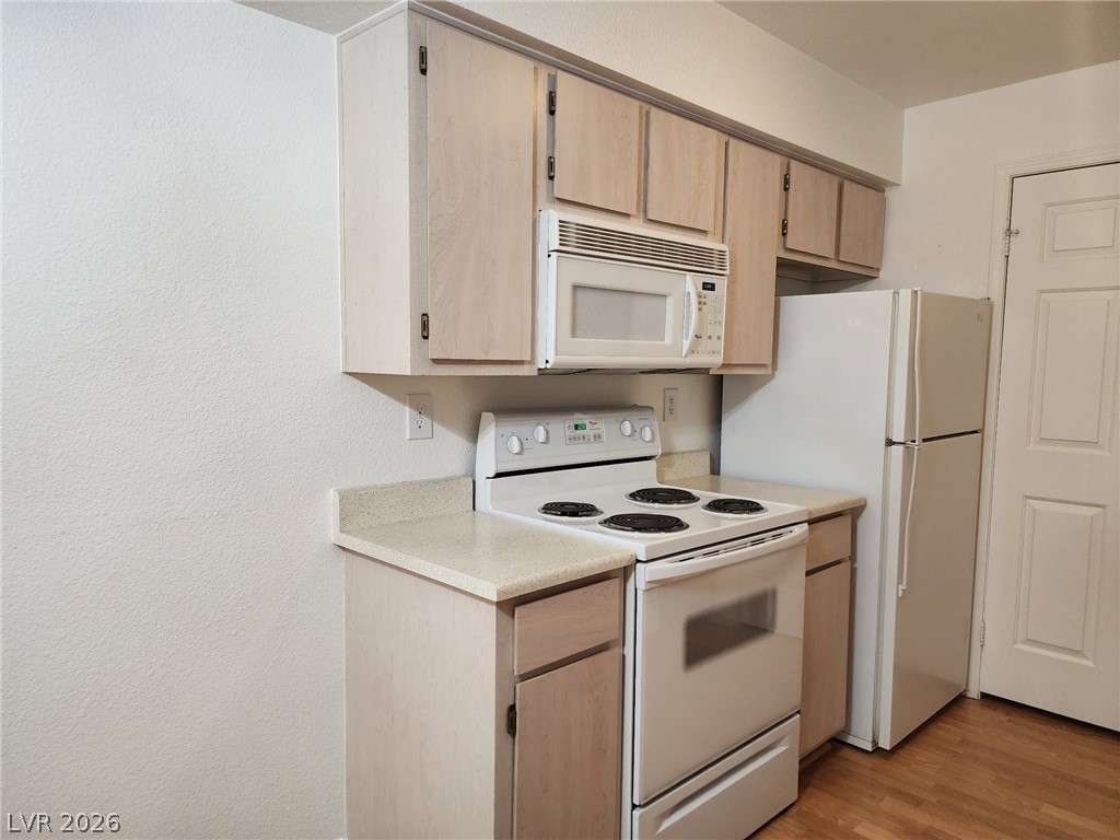 231 West Horizon Ridge Parkway, Unit 1127 Henderson, NV 89012 - Photo 16 of 39 A compact kitchen featuring essential appliances and light-toned cabinetry.