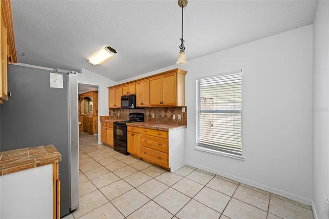 a kitchen with granite countertop cabinets and window