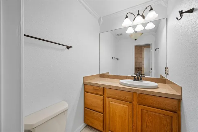 a bathroom with a sink vanity mirror and toilet