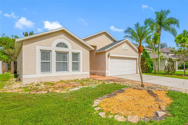 a front view of a house with a yard and trees