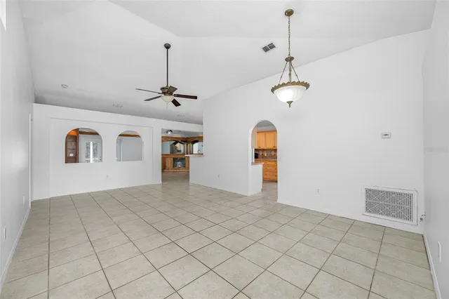 a view of a livingroom with a chandelier fan and windows
