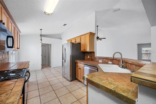 a kitchen with stainless steel appliances granite countertop a sink and a stove