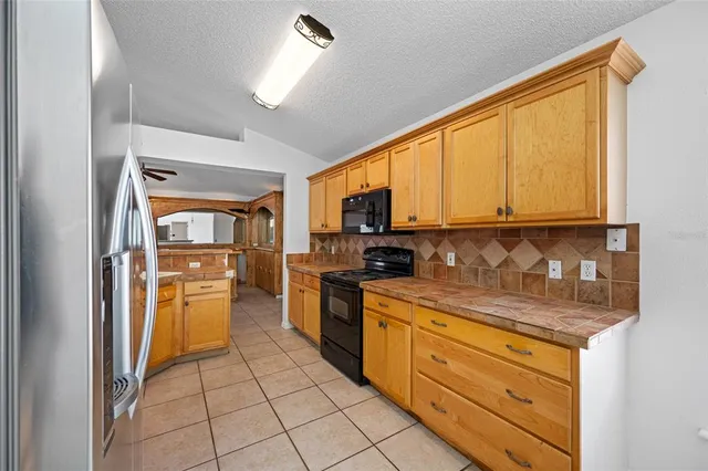 a kitchen with a refrigerator a stove top oven and a sink