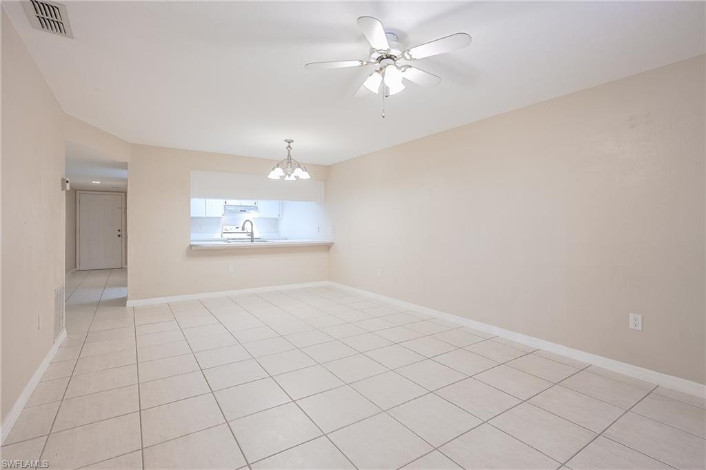 2370 Naples Trace Circle, Unit 7 Naples, FL 34109 - Photo 17 of 23 an empty room with chandelier fan and windows