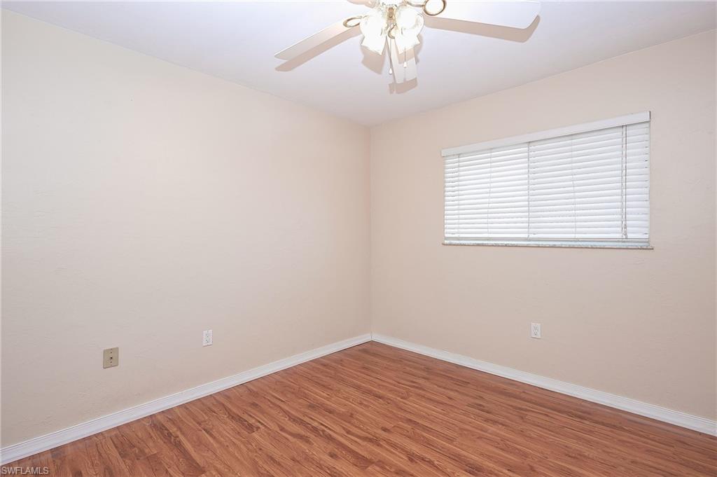 2370 Naples Trace Circle, Unit 7 Naples, FL 34109 - Photo 19 of 23 wooden floor in an empty room with a window