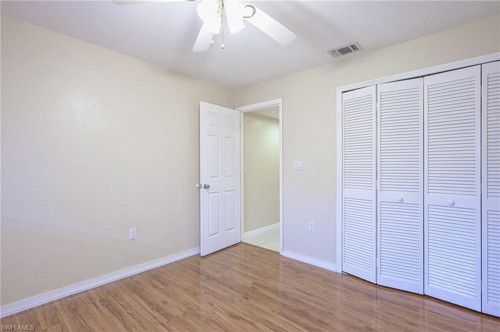 2370 Naples Trace Circle, Unit 7 Naples, FL 34109 - Photo 20 of 23 an empty room with wooden floor closet and windows