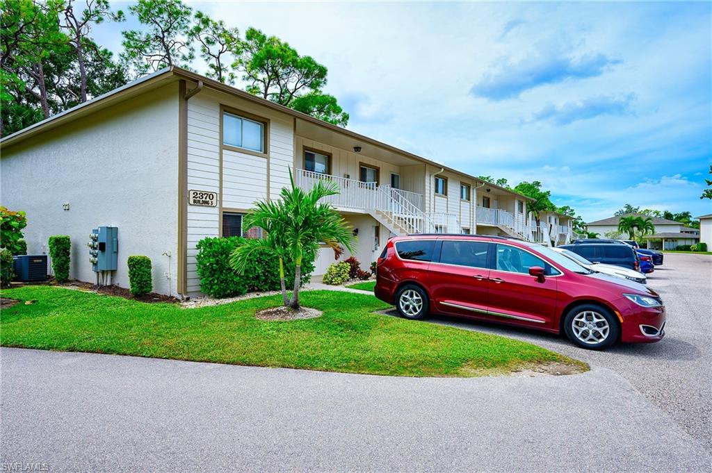 2370 Naples Trace Circle, Unit 7 Naples, FL 34109 - Photo 23 of 23 a front view of a house with a yard and garage