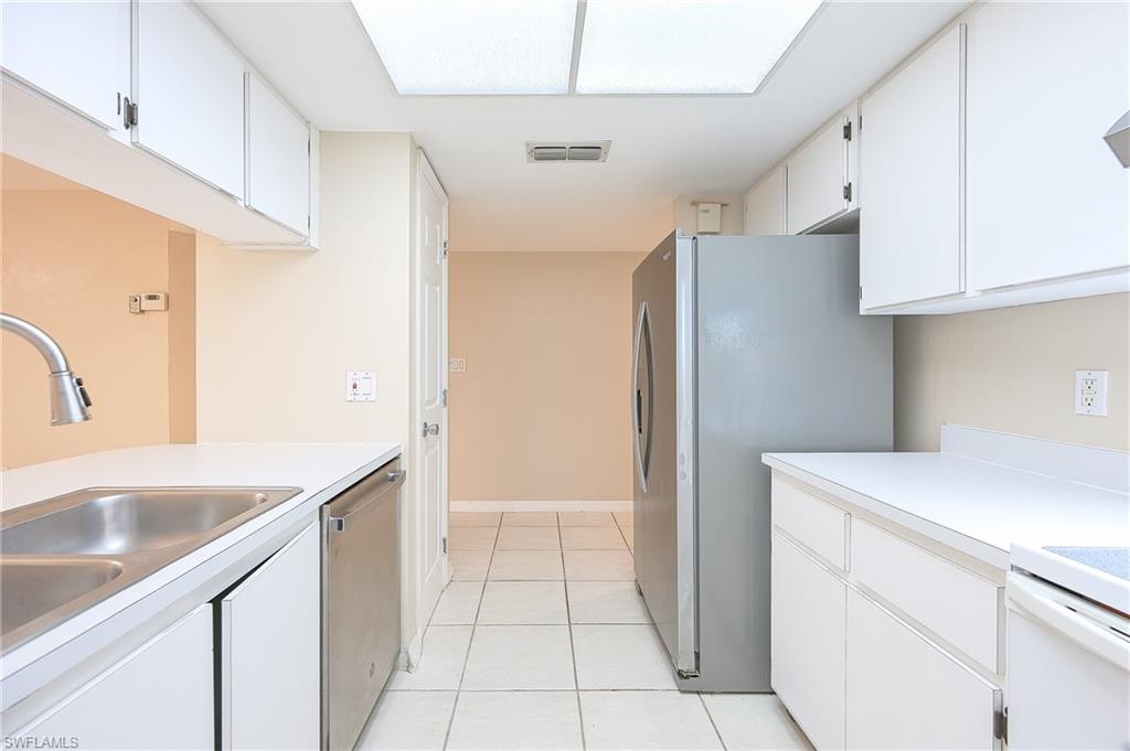 2370 Naples Trace Circle, Unit 7 Naples, FL 34109 - Photo 5 of 23 a kitchen that has a sink cabinets and a refrigerator