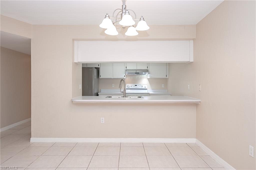 2370 Naples Trace Circle, Unit 7 Naples, FL 34109 - Photo 8 of 23 a bathroom with a sink a mirror and a lamp