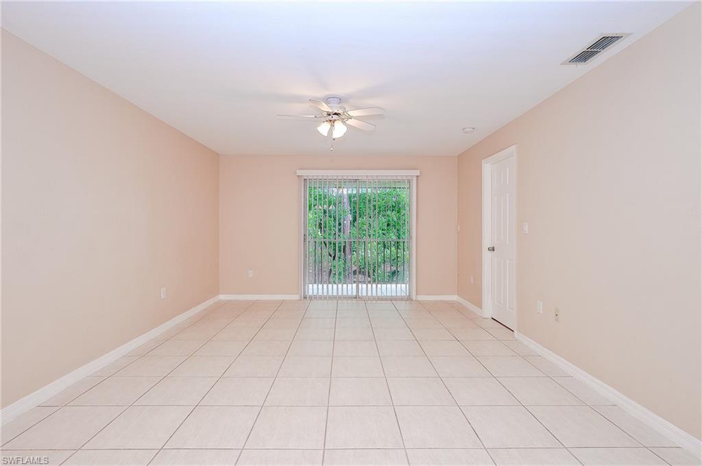 2370 Naples Trace Circle, Unit 7 Naples, FL 34109 - Photo 10 of 23 an empty room with windows and ceiling fan