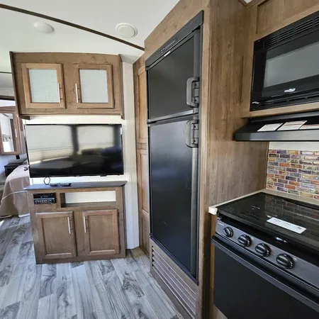 a kitchen with wooden floor and stainless steel appliances