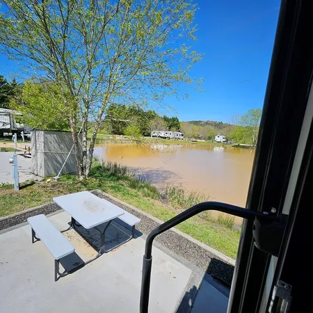 a front view of a house with a garden and lake view