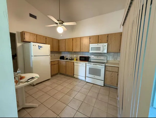 a kitchen with a refrigerator sink and cabinets