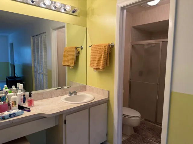 a bathroom with a granite countertop sink toilet and shower