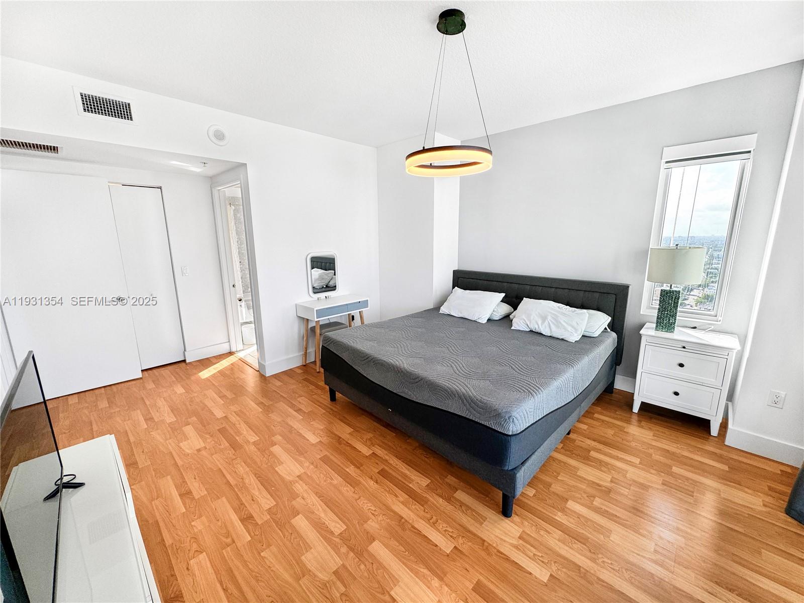 185 Southwest 7th Street, Unit 2701 Miami, FL 33130 - Photo 12 of 24 a bedroom with a bed and a night stand