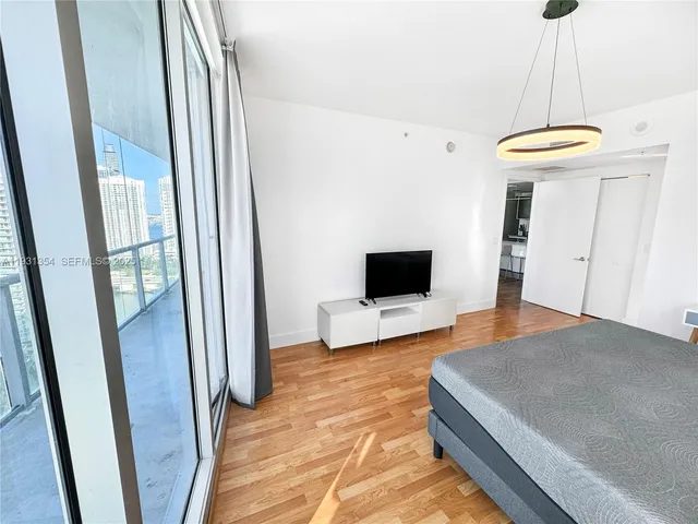 a bedroom with a bed and a flat screen tv