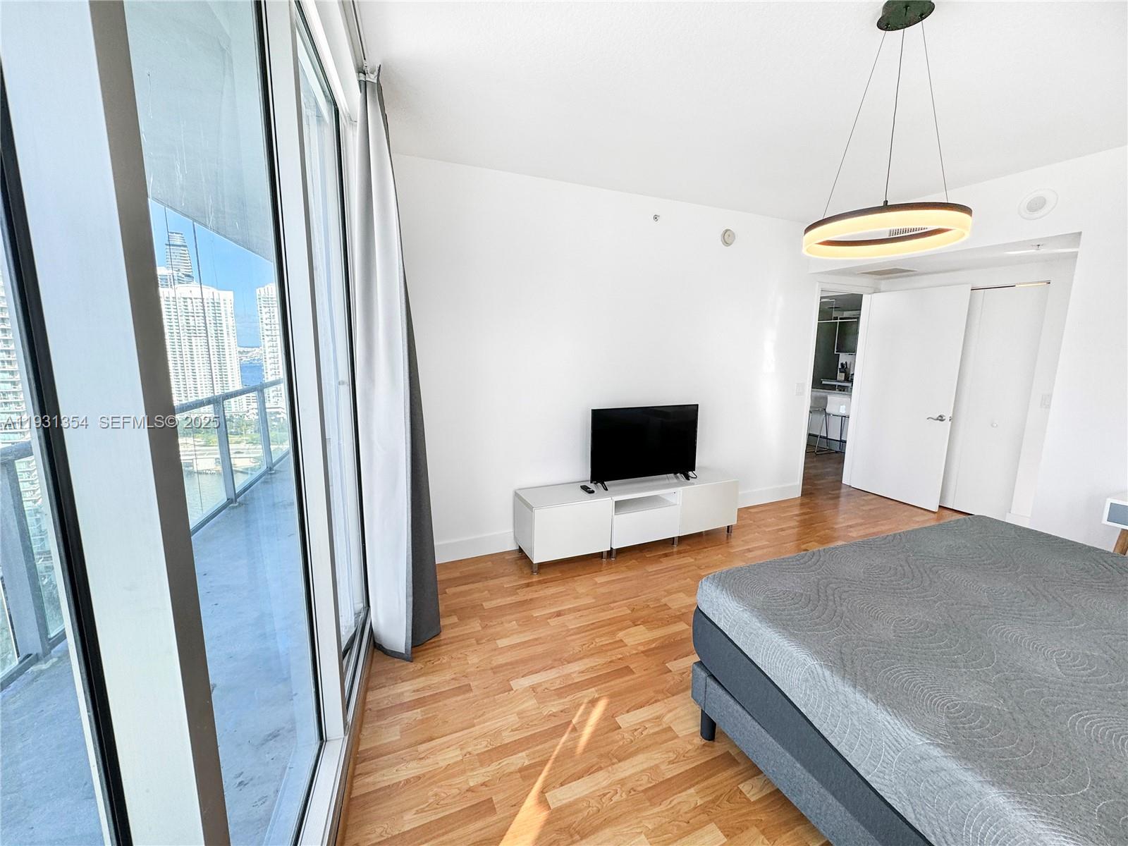 185 Southwest 7th Street, Unit 2701 Miami, FL 33130 - Photo 13 of 24 a bedroom with a bed and a flat screen tv