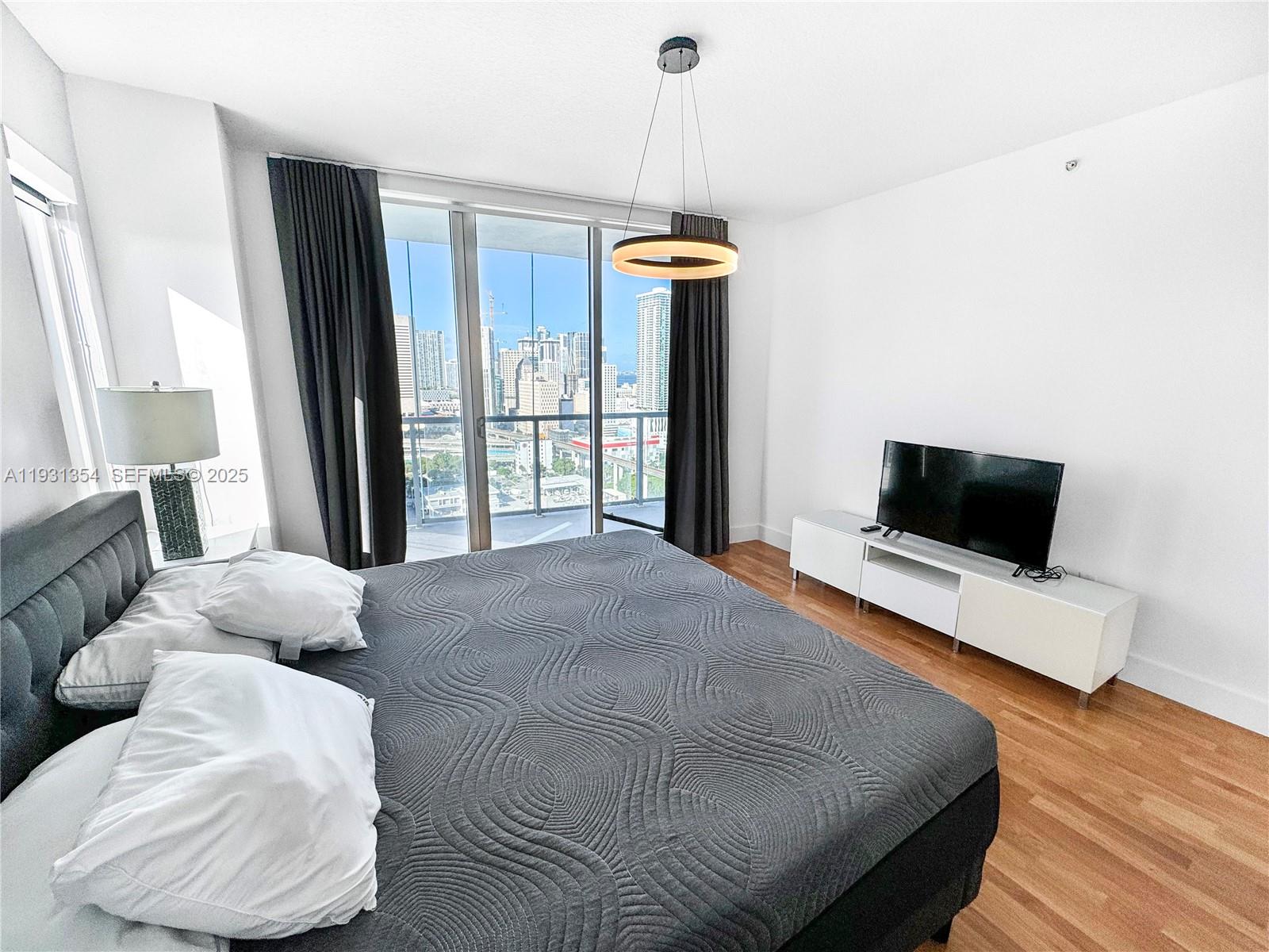 185 Southwest 7th Street, Unit 2701 Miami, FL 33130 - Photo 14 of 24 a bedroom with furniture and a flat screen tv