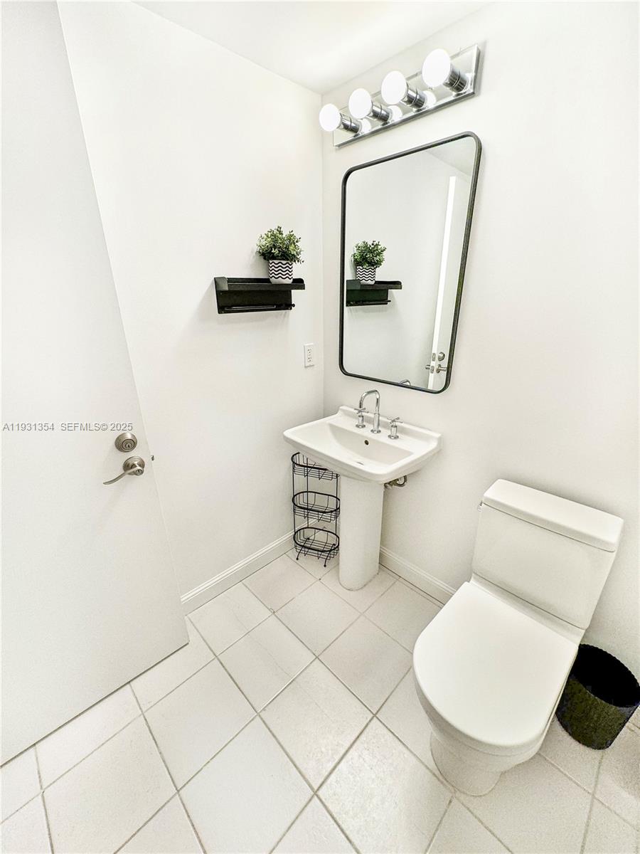 185 Southwest 7th Street, Unit 2701 Miami, FL 33130 - Photo 16 of 24 a bathroom with a toilet a sink and mirror