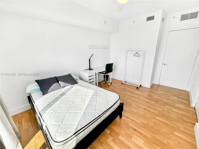 a bed sitting in a bedroom next to a window