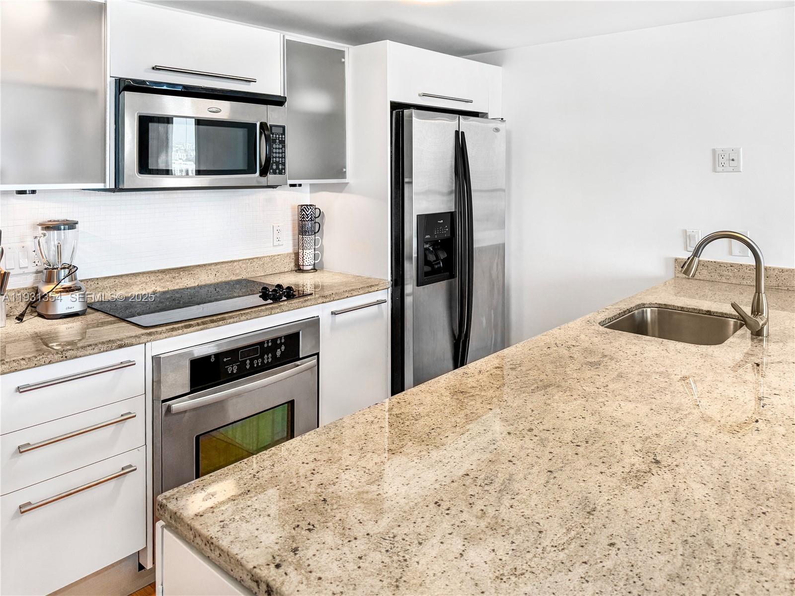 185 Southwest 7th Street, Unit 2701 Miami, FL 33130 - Photo 2 of 24 a kitchen with a stove and a microwave