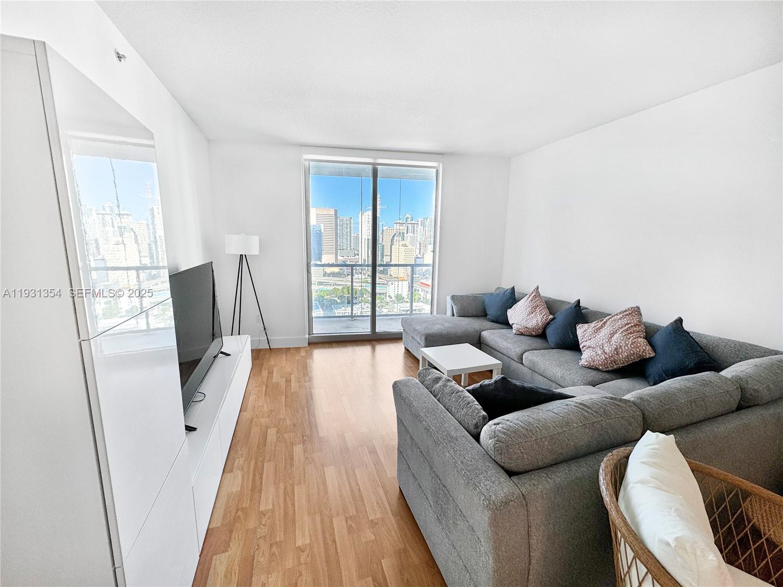 185 Southwest 7th Street, Unit 2701 Miami, FL 33130 - Photo 6 of 24 a living room with furniture and a large window