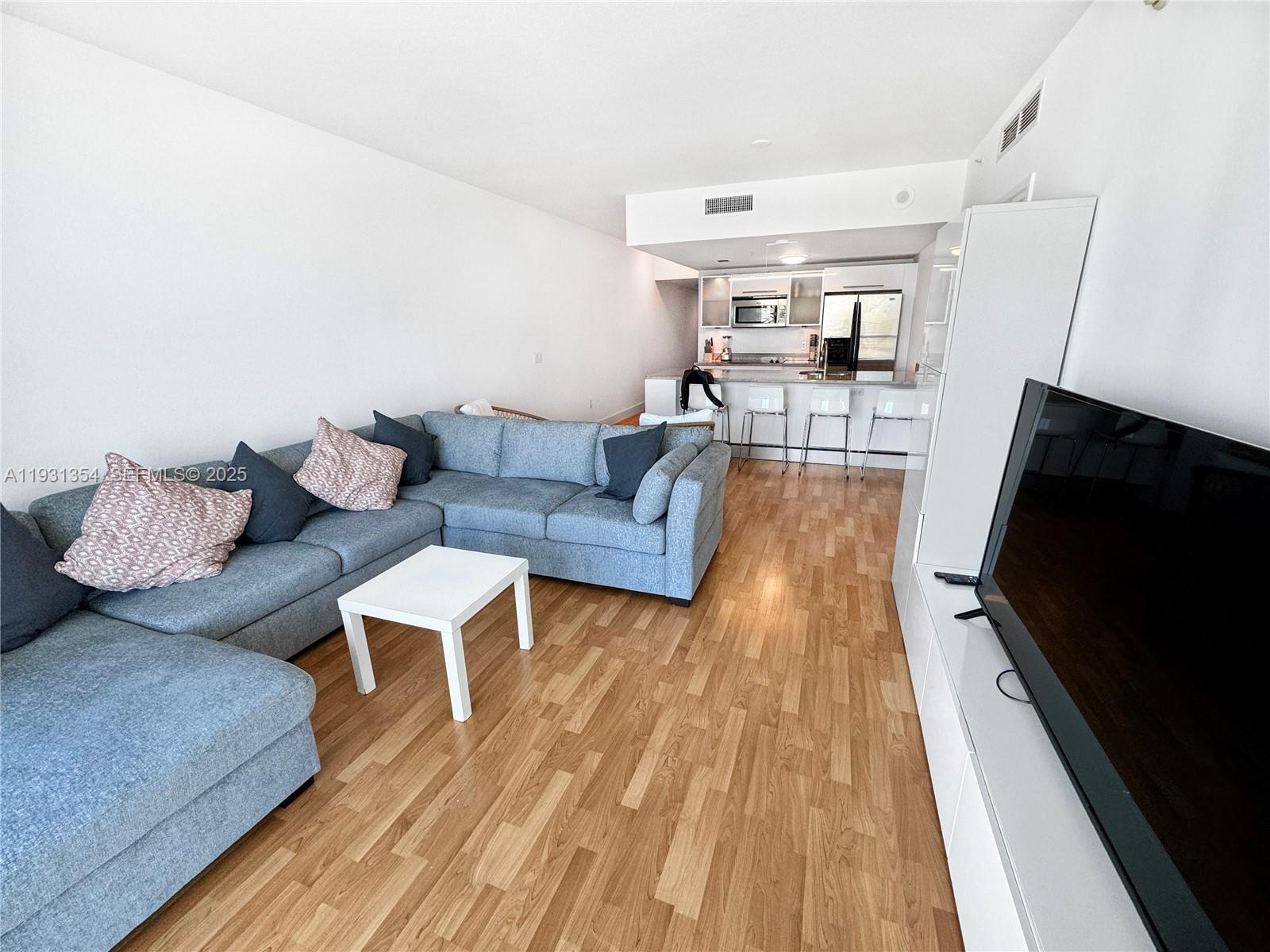 185 Southwest 7th Street, Unit 2701 Miami, FL 33130 - Photo 7 of 24 a living room with furniture and a flat screen tv
