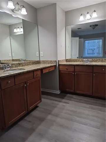 a spacious bathroom with a granite countertop sink and a mirror