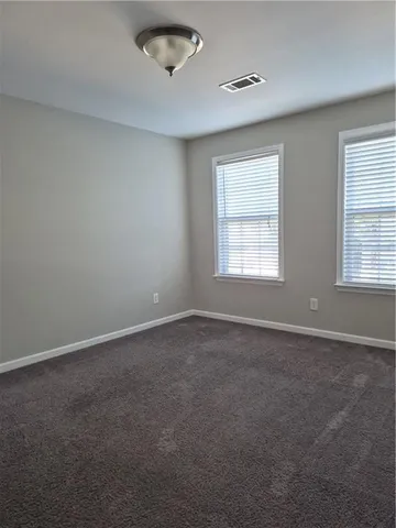 an empty room with a window and a kitchen