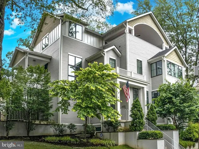 a front view of a house with plants and trees