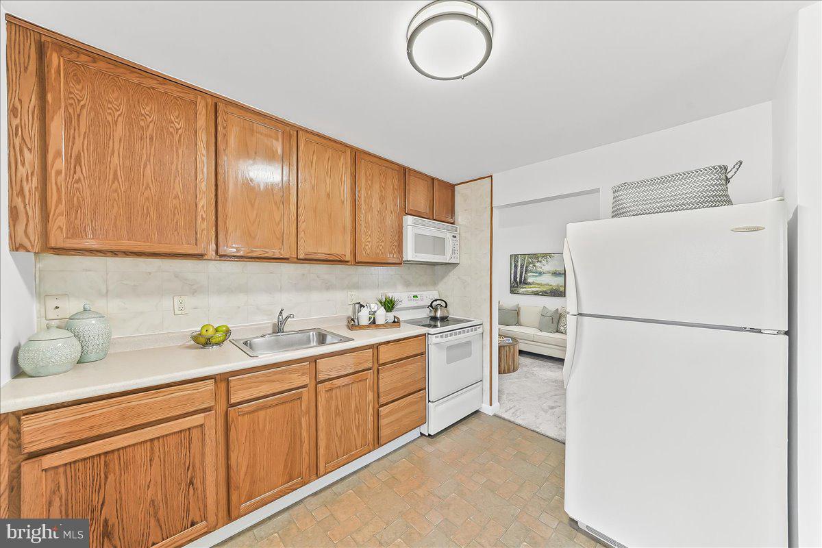 929 Crystle Road Aston, PA 19014 - Photo 11 of 18 a kitchen with sink a refrigerator and cabinets