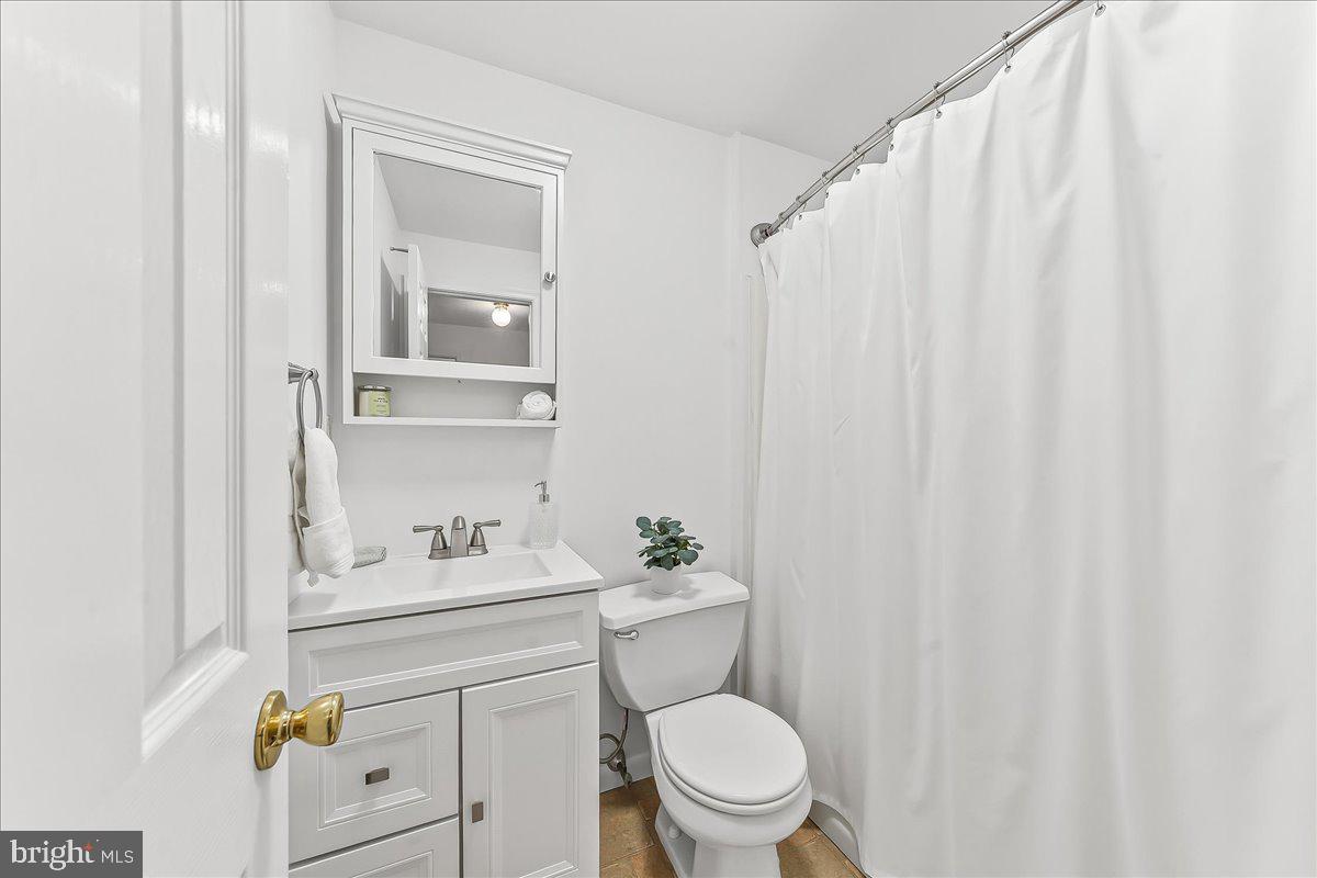 929 Crystle Road Aston, PA 19014 - Photo 12 of 18 a bathroom with a sink a toilet and shower curtain