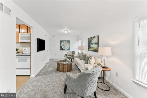 a living room with furniture a flat screen tv and a window