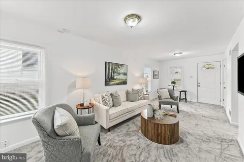 a living room with furniture a rug and a window