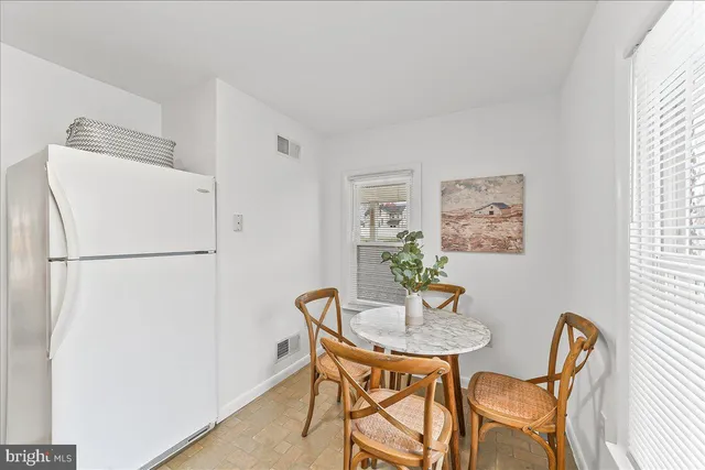 a dining room with furniture and a refrigerator